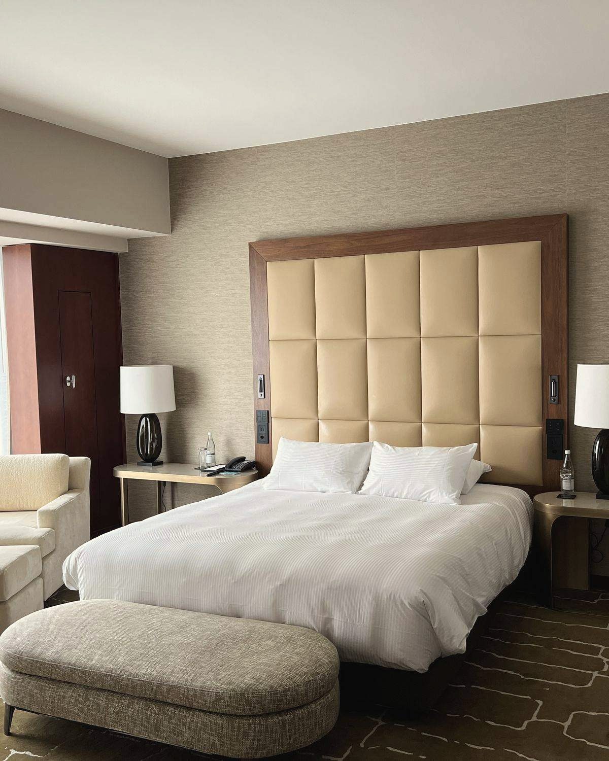 Hotelzimmer mit Doppelbett, Sessel und Polsterbank